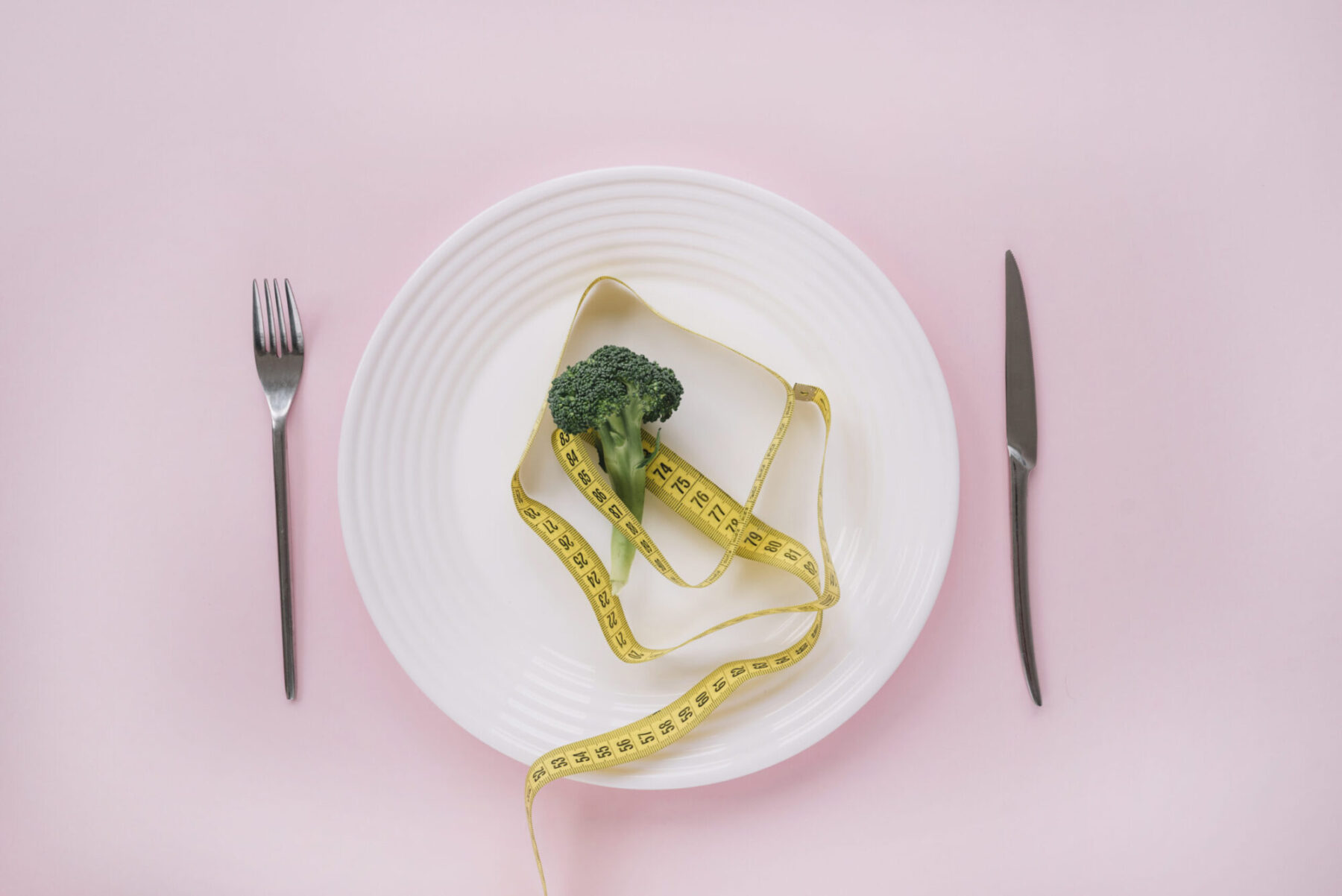piatto con poco cibo e un metro in studio nutrizionista a Ragusa e Vittoria